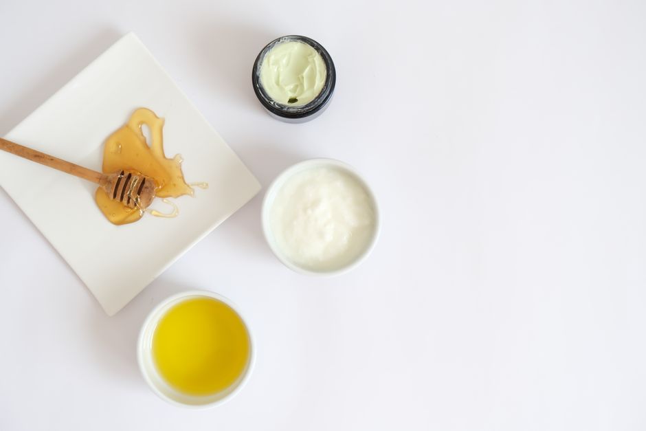 Flat lay image of honey, cream, oil, and natural ingredients for skincare.